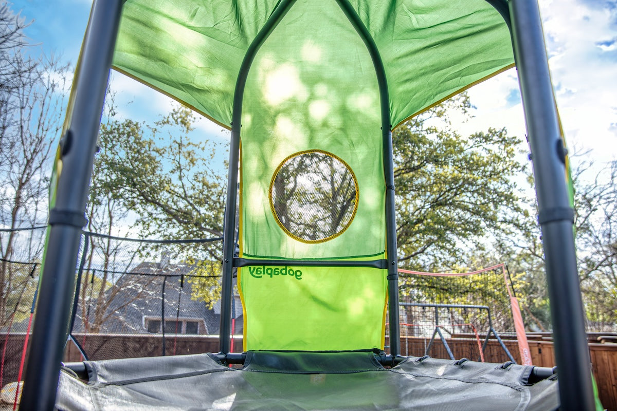 Shaded deck on a green kids climbing tower